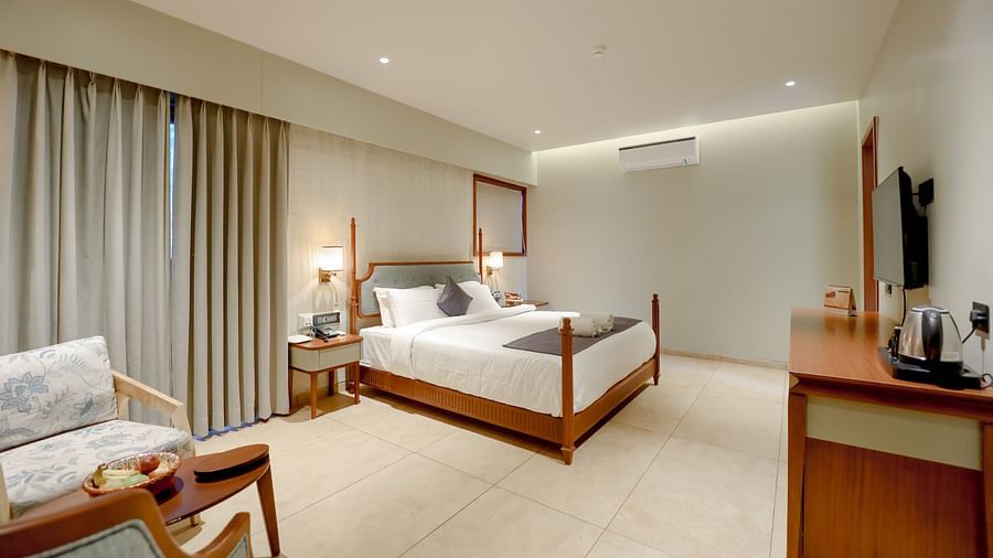 An image of a villa room featuring a king size bed and a seating area - Pride Resort Ambaji